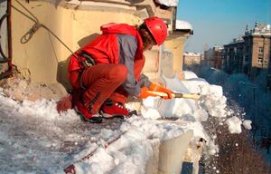 Чистка снега с крыши у одного из домов Пушкино